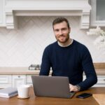 a man using a laptop building a blog on his work desk