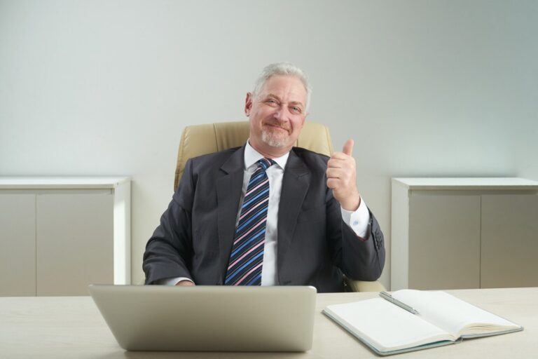 a senior man wearing formal clothes with thumbs up