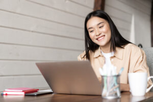 young woman smiling in front of a laptop